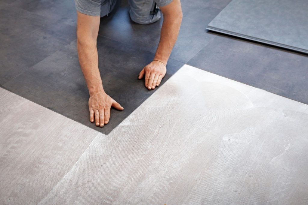 A man sprawled on the floor, featuring luxury vinyl tile flooring from a service in Washington, DC.