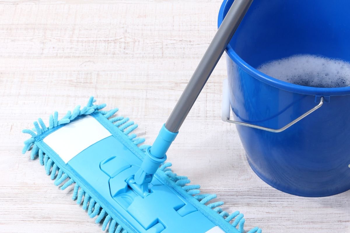 Cleaning floors with mop and a bucket filled with water