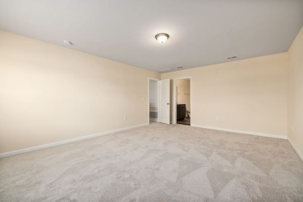 An empty room with beige walls and carpet, representing a clean area for showcasing flooring services in Washington, DC.