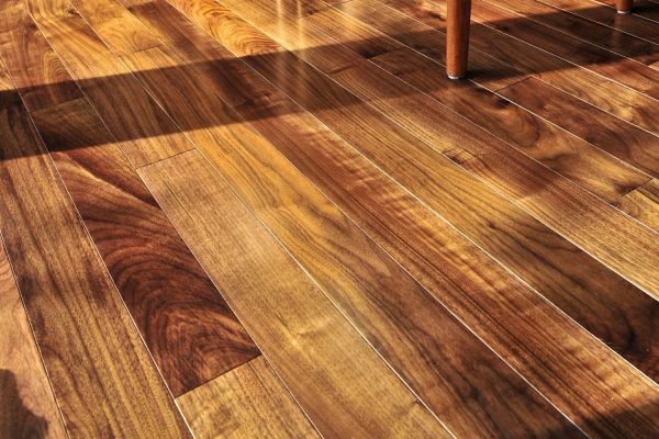 Sunlight illuminates a polished wooden floor, showcasing the beauty of hardwood tile flooring in Washington, DC.